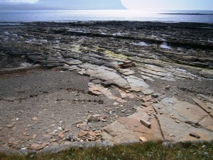 Sandstone pavement at low tide off the island of Mainland, Orkney. The Mouth of Hoy and part o fthe mountainous island of Hoy in the background